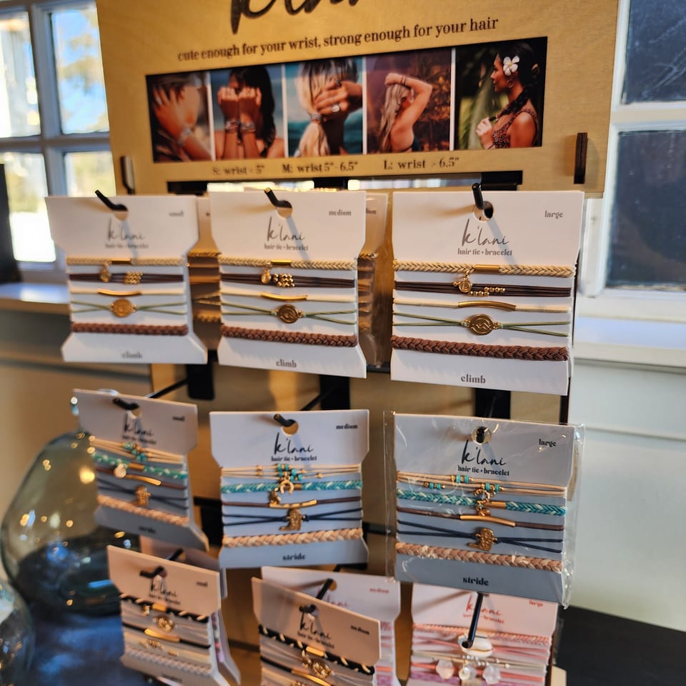 Retail display showcasing colorful Klani hair ties and bracelets in small, medium, and large sizes.